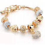 Arany színű charm karkötő cirkóniás charmokkal és szív medállal