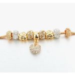 Arany színű charm karkötő cirkóniás charmokkal és szív medállal