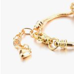 Arany színű charm karkötő cirkóniás charmokkal és szív medállal