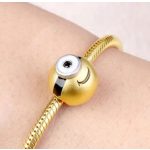 Minyon charm arany tónusban egyszemű figurával 